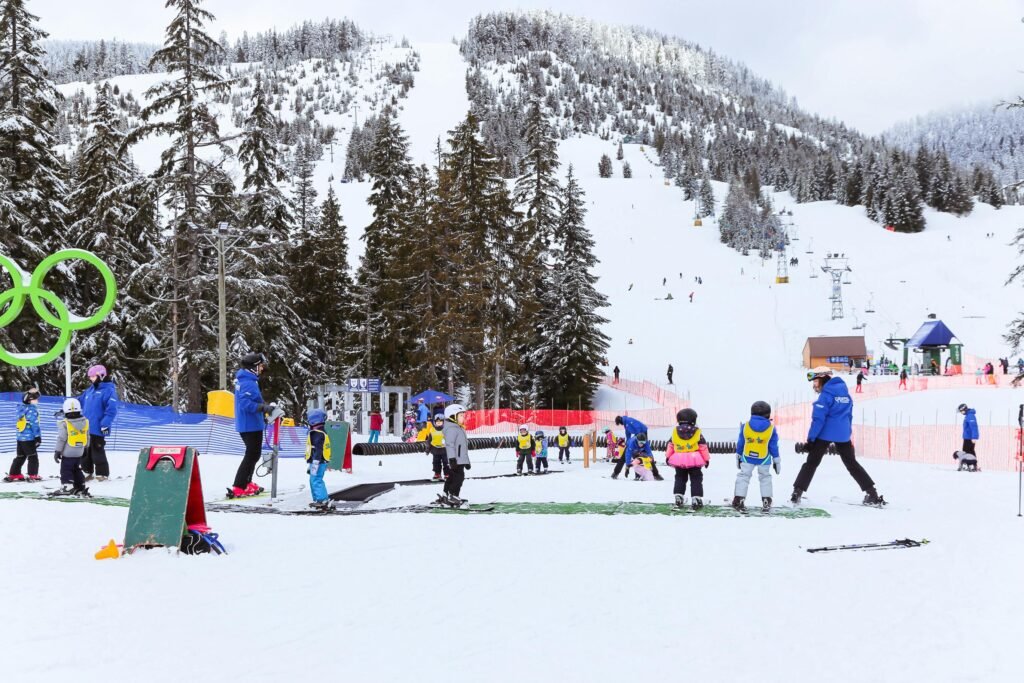 Children learning to ski during a winter lesson at a snow-covered mountain resort.