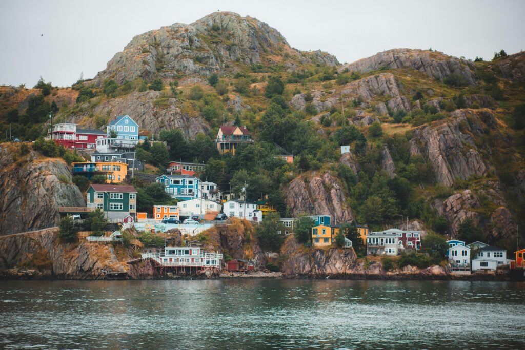 Vibrant houses line the rocky coastline, creating a picturesque coastal village scene.