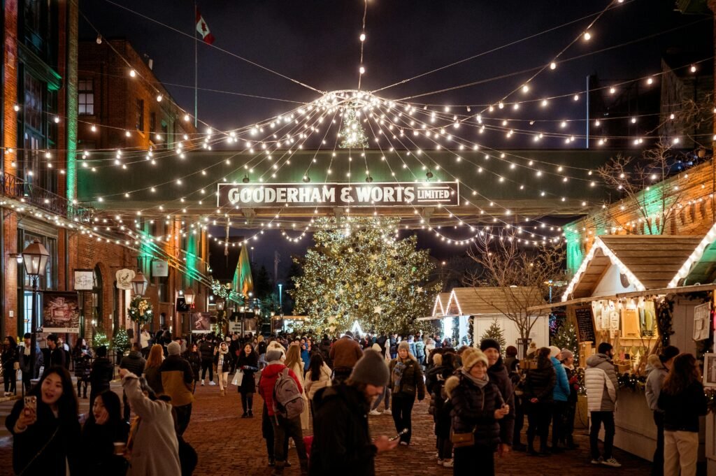 Night scene of a bustling Christmas market with festive lights and decorations.