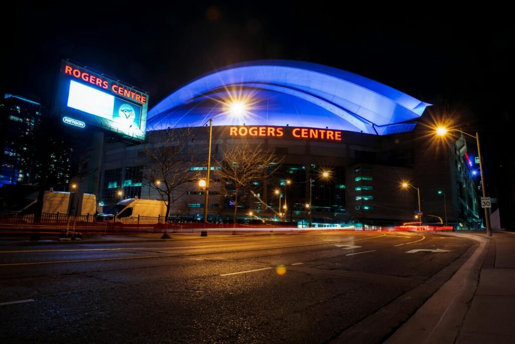 Night view of the illuminated Rogers Centre in Toronto, a famous landmark and tourist attraction.